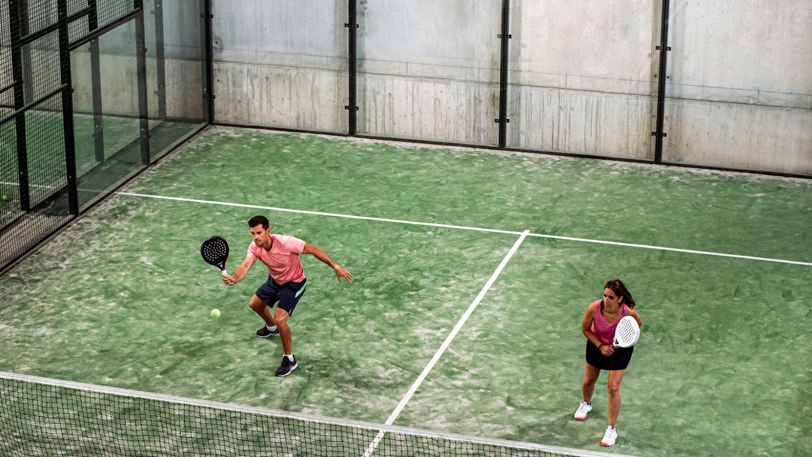 Coppia di giocatori di Padel in campo durante uno scambio