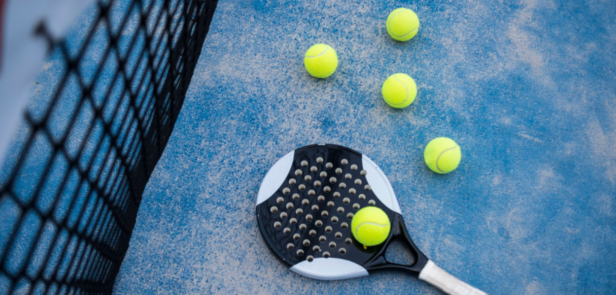 Una racchetta di padel in campo con palline